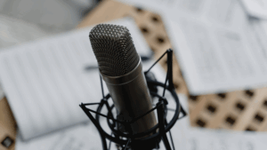 A microphone in the foreground. In the background are some blurred books