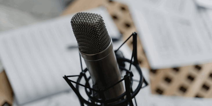 A microphone in the foreground. In the background are some blurred books